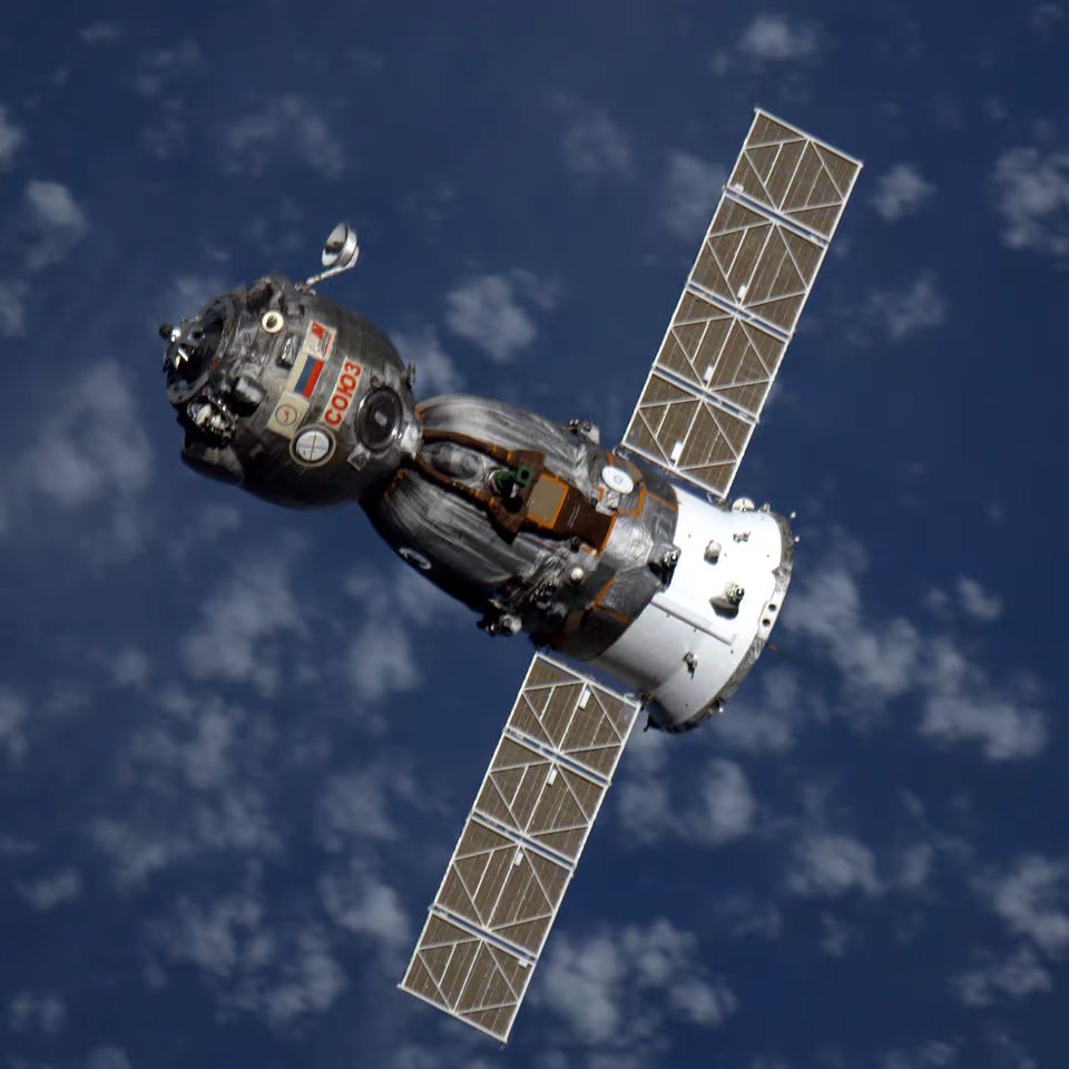 A Soyuz spacecraft with Earth below it.