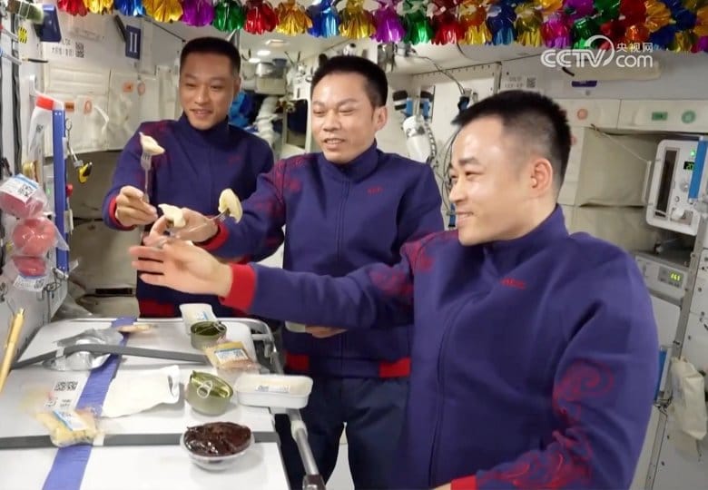 Jiang Xinlin (left), Tang Hongbo (center), and Tang Shengjie (right) sharing a meal as part of the Chinese New Year celebrations aboard China's space station. ©China Manned Space Agency/China Central Television