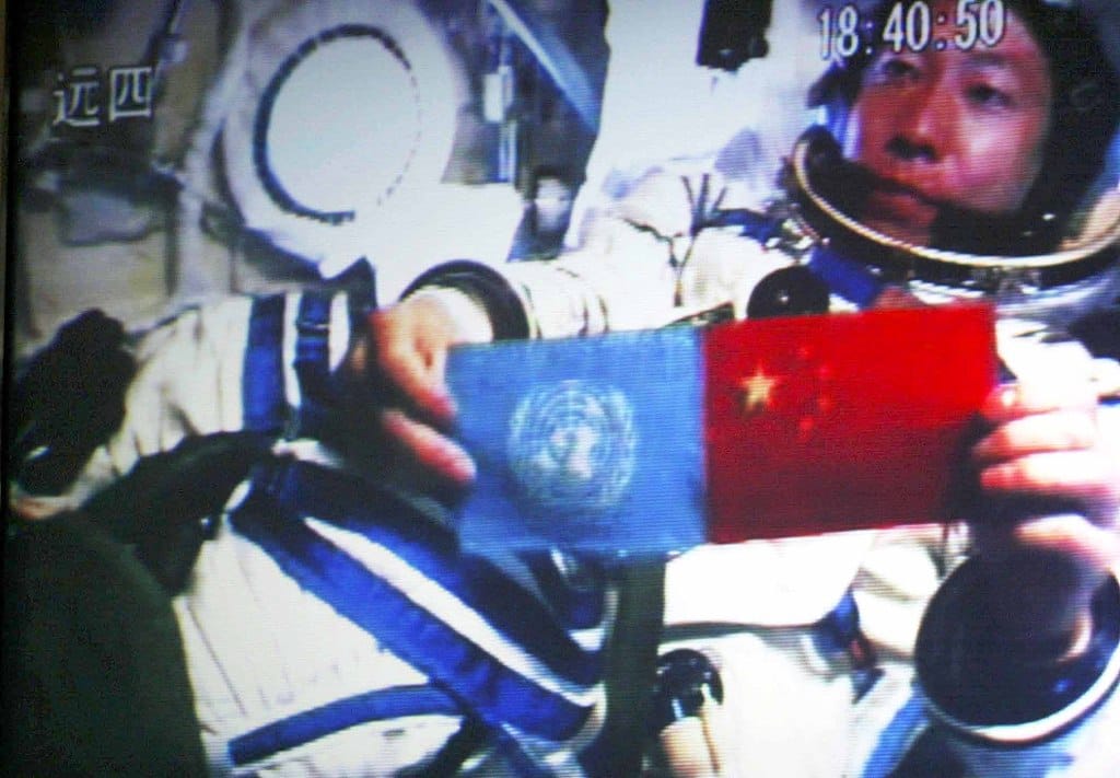 Yang Liwei after unfurling the flags of the United Nations (left) and the People's Republic of China (right) inside the Shenzhou-5 spacecraft in orbit.