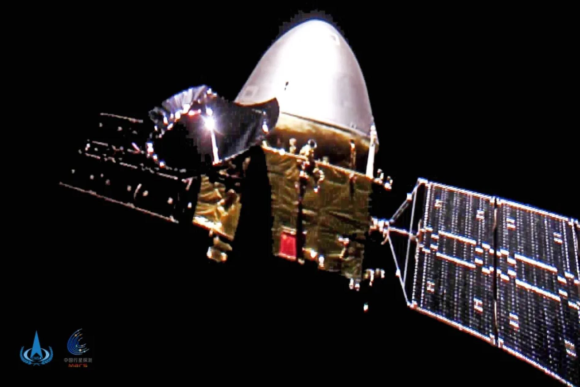 The Tianwen-1 orbiter with the lander and rover still inside the atmospheric descent capsule photographed in deep space by a deployable camera.