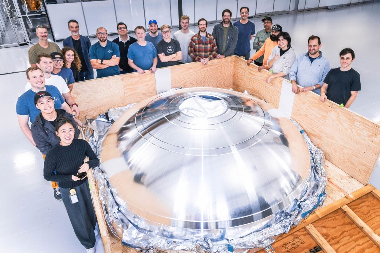 One of the domes for the Helios kick-stage, partially unboxed and surrounded by Impulse Space's team. ©Impulse Space