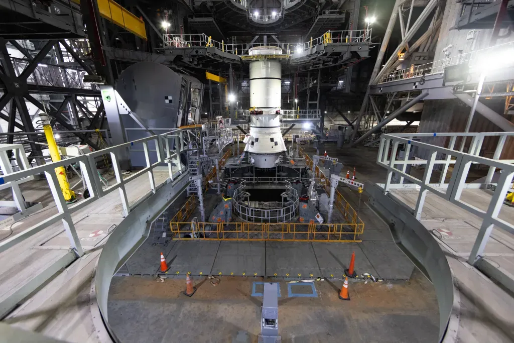 NASA teams stacking the first solid rocket booster segment inside the Vehicle Assembly Building. ©Glenn Benson/NASA